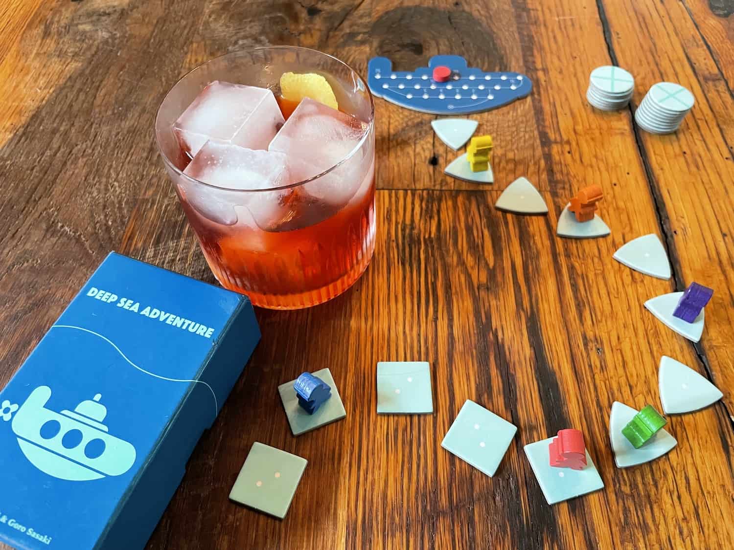 the board game Deep Sea Adventure with a Boulevardier cocktail